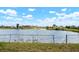 Wide lake view from backyard with green grass and fence on property line at 4740 Payne St, North Port, FL 34287