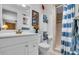 Well-lit bathroom with a modern vanity, toilet, and shower with a blue and white curtain at 491 Conrad Rd, Venice, FL 34293
