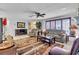 Spacious living room featuring a fireplace, neutral-toned furniture, tiled floor, and a ceiling fan at 491 Conrad Rd, Venice, FL 34293