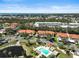 Aerial view features a community pool near villas with stunning waterfront views and lush landscaping at 503 Pine Hollow Cir # 503, Englewood, FL 34223