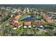 Aerial view showcases villas with red roofs, a central pond, and beautifully maintained landscaping at 503 Pine Hollow Cir # 503, Englewood, FL 34223