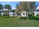 Backyard featuring a lush lawn, mature landscaping and views of the property and neighboring buildings at 503 Pine Hollow Cir # 503, Englewood, FL 34223