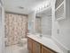 Bathroom with a tropical-themed shower curtain, vanity and large mirror at 503 Pine Hollow Cir # 503, Englewood, FL 34223