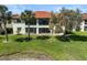 Exterior showcasing manicured lawn and mature landscaping, offering privacy and shade for outdoor activities at 503 Pine Hollow Cir # 503, Englewood, FL 34223
