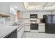 Efficient kitchen layout featuring white cabinets, black appliances, and a convenient breakfast nook at 503 Pine Hollow Cir # 503, Englewood, FL 34223