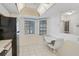 Bright kitchen featuring white tile floor and a table beneath two windows at 503 Pine Hollow Cir # 503, Englewood, FL 34223