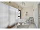Enclosed lanai with white table and chairs, vertical blinds, and tropical decor for relaxed indoor-outdoor living at 503 Pine Hollow Cir # 503, Englewood, FL 34223