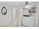 Laundry room featuring a washer and dryer, storage shelves, and easy access to the bathroom at 503 Pine Hollow Cir # 503, Englewood, FL 34223