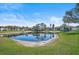 Community featuring a tranquil pond with lush landscaping, creating a serene and picturesque setting for residents at 503 Pine Hollow Cir # 503, Englewood, FL 34223