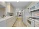 Efficient kitchen design with white appliances, tile floors, and ample cabinet space at 521 Circlewood Dr # Q11, Venice, FL 34293