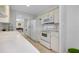 Galley kitchen with white appliances, long countertops, and tile flooring at 521 Circlewood Dr # Q11, Venice, FL 34293