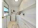 Bright laundry room featuring all-white cabinets, gold hardware, and a window at 521 Circlewood Dr # Q11, Venice, FL 34293