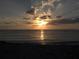 Sunset over ocean waters with sunbeams shining through the clouds at 521 Circlewood Dr # Q11, Venice, FL 34293
