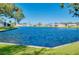 Stunning water view with lush green lawn and mature trees under a clear blue sky at 521 Circlewood Dr # Q11, Venice, FL 34293
