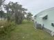 Exterior view of the home and backyard featuring mature trees at 524 S Cervina Dr, Venice, FL 34285