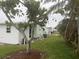 Backyard view of home featuring mature trees and green grass at 524 S Cervina Dr, Venice, FL 34285