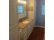 Bathroom with a tan countertop sink, white cabinets and blue walls at 524 S Cervina Dr, Venice, FL 34285