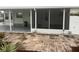 Exterior view of home with stone patio and enclosed porch at 524 S Cervina Dr, Venice, FL 34285