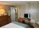 Cozy bedroom featuring a dresser, TV on a desk, and a connecting bathroom with a neutral color palette at 532 Via Veneto, Venice, FL 34285
