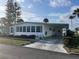 Charming single-story home with a covered driveway, lush landscaping, and white exterior at 532 Via Veneto, Venice, FL 34285