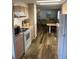 Galley kitchen with appliances, wood-look flooring, and an eat-in table at 532 Via Veneto, Venice, FL 34285