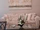 Comfortable living room featuring a plush sofa, glass coffee table, and a decorative painting, creating a relaxing atmosphere at 601 Club House Rd, Venice, FL 34285