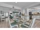 Bright dining room with glass top table and view into the kitchen and living room at 605 Valencia Rd, Venice, FL 34285