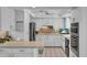 Well-lit kitchen featuring white cabinets, stainless steel appliances, and tile flooring at 605 Valencia Rd, Venice, FL 34285