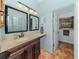 Bathroom boasts a vanity with sink, decorative mirrors, and adjacent toilet room, complemented by beach accents at 613 Sugarwood Dr, Venice, FL 34292