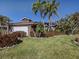 Charming single-story home with a manicured lawn, lush landscaping, and a two-car garage at 613 Sugarwood Dr, Venice, FL 34292