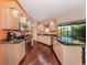 Bright kitchen with stainless appliances, granite counters, beautiful wood floors and a view of the lanai at 613 Sugarwood Dr, Venice, FL 34292