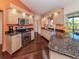 Bright kitchen with stainless appliances, granite counters, beautiful wood floors and a view of the lanai at 613 Sugarwood Dr, Venice, FL 34292