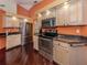 Modern kitchen featuring stainless steel appliances, granite countertops, and rich dark hardwood flooring at 613 Sugarwood Dr, Venice, FL 34292