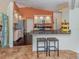 Well-lit kitchen boasting stainless steel appliances, granite countertops, and a cozy breakfast bar at 613 Sugarwood Dr, Venice, FL 34292