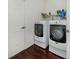 Bright laundry room features a modern washer and dryer set and convenient shelving above at 613 Sugarwood Dr, Venice, FL 34292