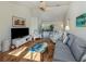 Bright living room with tiled floors, ceiling fan, beach-themed decorations, and comfortable seating arrangement at 613 Sugarwood Dr, Venice, FL 34292