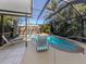 Inviting screened-in pool area featuring a sparkling pool and relaxing lounge chairs at 613 Sugarwood Dr, Venice, FL 34292