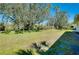 A large, grassy backyard is seen adjacent to mature trees at 616 Circlewood Dr # S2-14, Venice, FL 34293