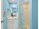 Bathroom with sky blue walls, a white vanity and a shower with a patterned curtain at 616 Circlewood Dr # S2-14, Venice, FL 34293