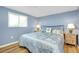 Bedroom with blue walls, wood floors, queen sized bed, and nautical themed decor at 616 Circlewood Dr # S2-14, Venice, FL 34293