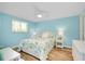 Bedroom features a floral bedspread, ceiling fan, bright window and wicker furnishings at 616 Circlewood Dr # S2-14, Venice, FL 34293