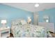 Bright bedroom featuring a floral patterned bedspread, a ceiling fan, and wicker furnishings at 616 Circlewood Dr # S2-14, Venice, FL 34293