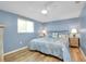 Bedroom with blue walls, wood floors, nautical decor, and an abundance of natural light at 616 Circlewood Dr # S2-14, Venice, FL 34293
