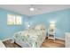 Comfortable bedroom featuring a floral patterned bedspread, a ceiling fan, and a bright window at 616 Circlewood Dr # S2-14, Venice, FL 34293