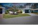 Charming single-story home featuring a screened-in porch, blue trim and mature tree in yard at 616 Circlewood Dr # S2-14, Venice, FL 34293