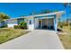 Charming single-story home featuring a screened-in porch, blue trim and well-maintained landscaping at 616 Circlewood Dr # S2-14, Venice, FL 34293