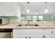 Kitchen view with stainless steel sink, white cabinets, and pendant lighting above countertop at 616 Circlewood Dr # S2-14, Venice, FL 34293