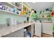 Practical laundry room with countertop, shelving, washer, and dryer at 616 Circlewood Dr # S2-14, Venice, FL 34293