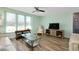 Cozy living room features wood flooring, a ceiling fan, and bright natural light from the large windows at 616 Circlewood Dr # S2-14, Venice, FL 34293