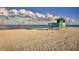 Classic lifeguard tower on a sandy beach, under a bright sky filled with fluffy white clouds at 632 Golf Dr # 632, Venice, FL 34285